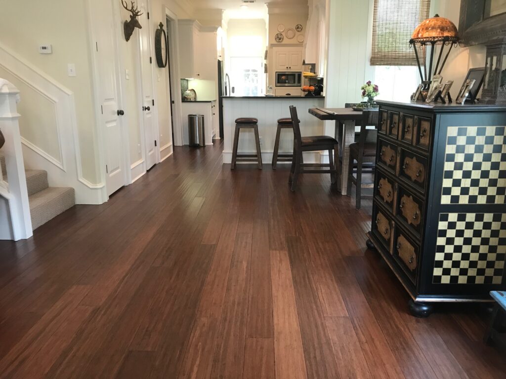 Dark brown hardwood flooring in an old home kitchen and dining area