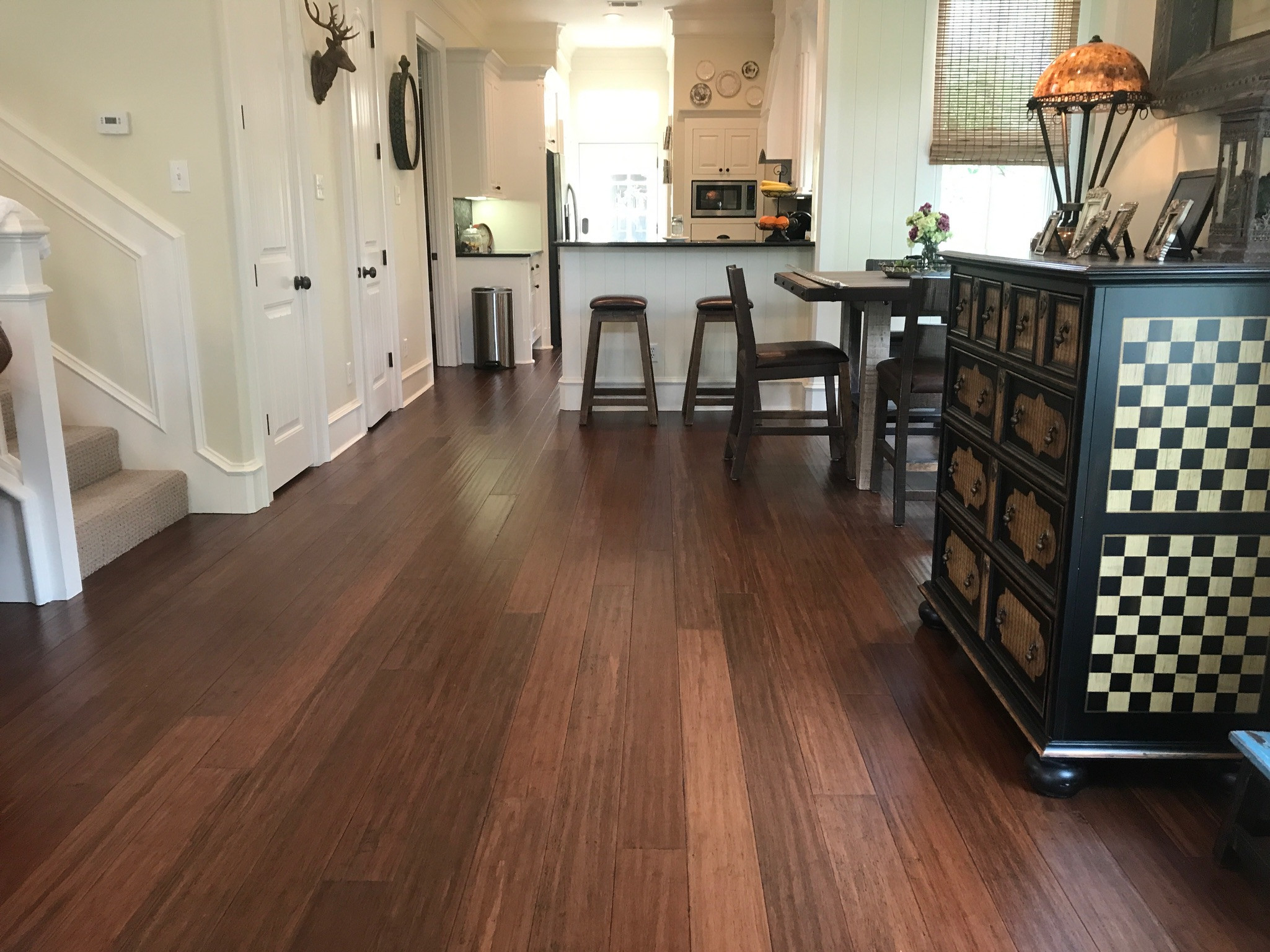 Dark brown hardwood flooring in an old home kitchen and dining area
