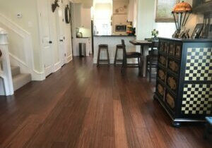 Dark brown hardwood flooring in an old home kitchen and dining area