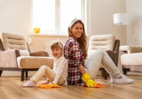 Family cleaning luxury vinyl flooring in a bright living room